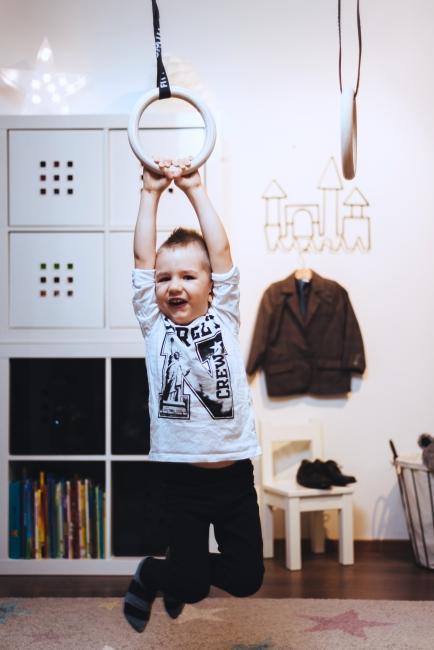 Lapsi roikkumassa FitWood GYM RINGS KIDS lasten voimistelurenkailla